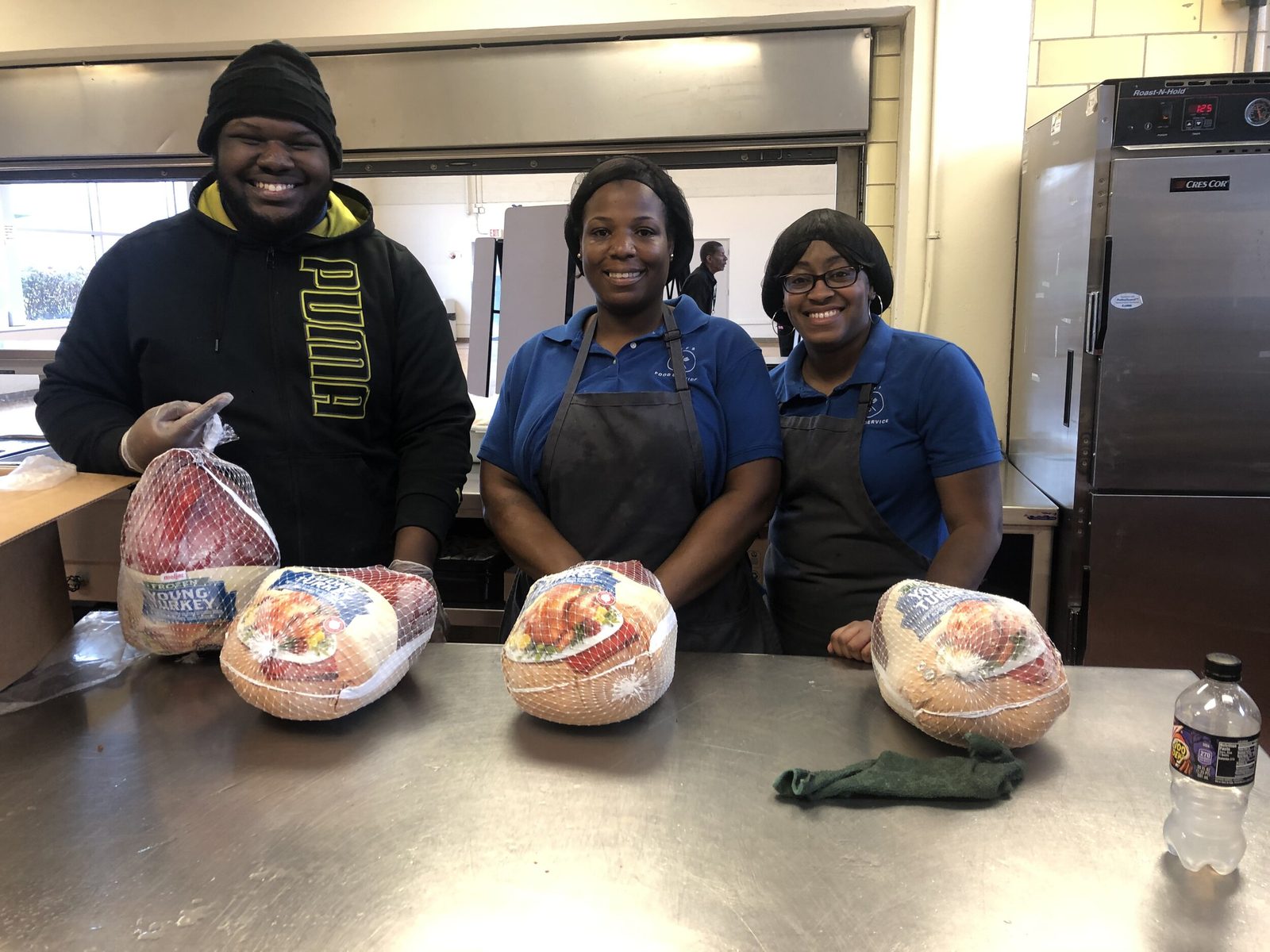 The KEYS commissary team gathered together holding Thanksgiving turkey gift bags ready for distribution to Metro Detroit families
